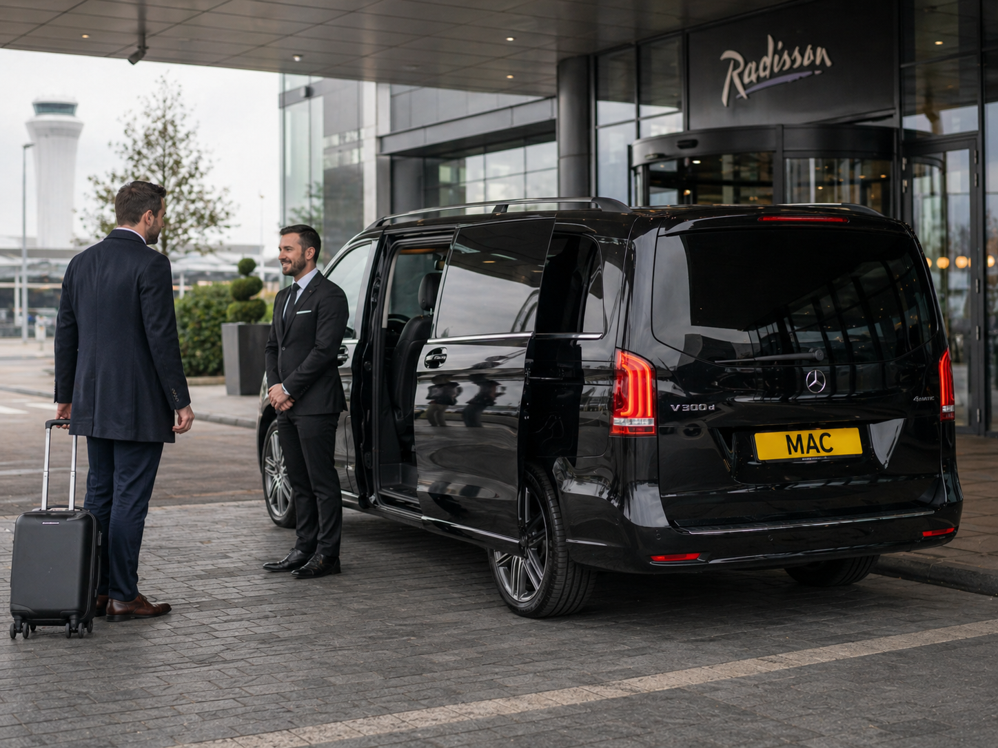 Manchester Airport hourly chauffeur services for VIP arrival travel with a black Mercedes V-Class, MAC number plate and professional chauffeur greeting a passenger at an airport hotel