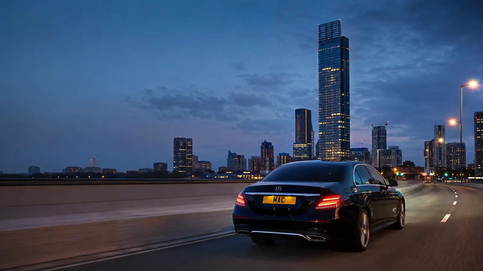 Black MAC Mercedes travelling toward Manchester city centre at dusk